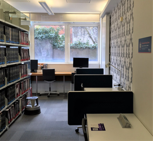 desks against a wall, behind them desks facing a window
